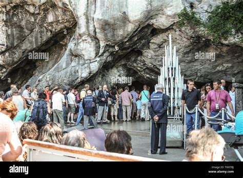 Gruppo di pellegrini che recita il rosario davanti alla Grotta di Massabielle