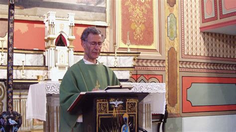 Ritratto di Don Rossano Santoro sorridente in abiti sacerdotali