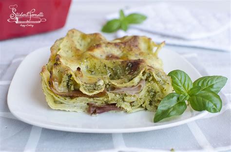 Foto di lasagne al pesto e speck fumanti in una teglia da forno