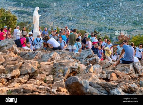Un gruppo di pellegrini che pregano inginocchiati sulla collina di Podbrdo a Medjugorje