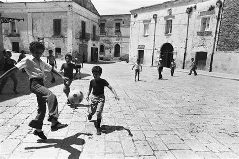 bambini che giocano in piazza, alcuni attivi e altri seduti apatici, simbolo di coinvolgimento e indifferenza