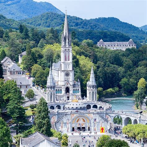Un pellegrino in preghiera in uno spazio verde del Santuario di Lourdes