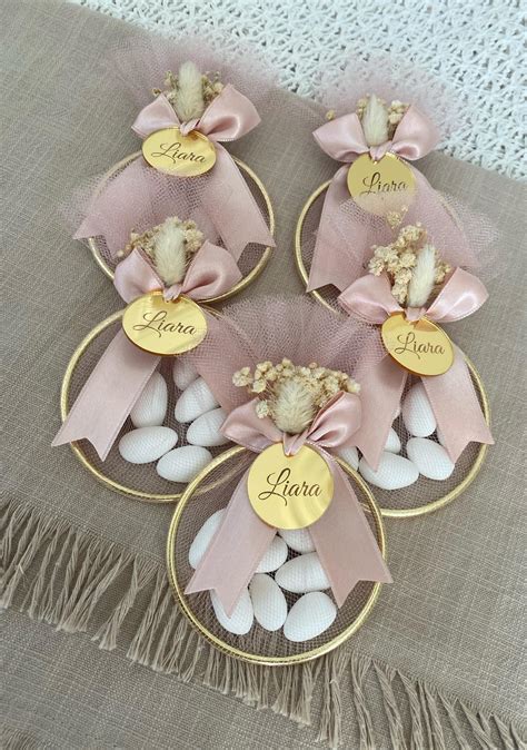 Foto di bomboniere a forma di campanella per battesimo, finemente decorate e personalizzate