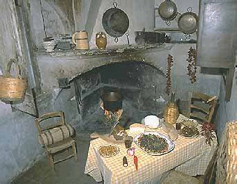 Un tipico focolare di una casa povera o contadina del primo Ottocento con sedie impagliate, fiasco e paiolo.