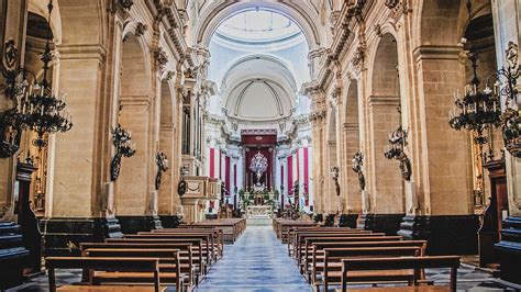 Fotografia di una solenne celebrazione liturgica nella Cattedrale di San Miniato, con particolare enfasi sulla processione e sugli elementi decorativi sacri.