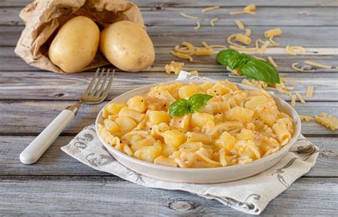 Foto di un piatto fumante di pasta e patate napoletana con basilico fresco