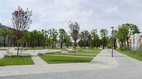 Un'ampia veduta di un parco cittadino riqualificato con prati curati, alberi rigogliosi e sentieri moderni che si integrano nel tessuto urbano