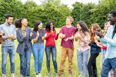 Foto di giovani in un gruppo di discussione o attività all'aperto che simboleggia la comunità