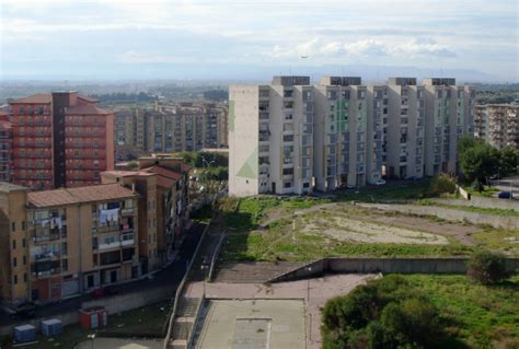 Foto di un quartiere periferico di Roma, con edifici popolari e spazi aperti che mostrano contrasti