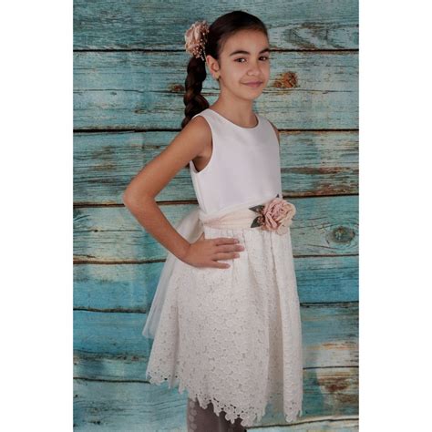 Dettaglio di un abito da comunione con particolari in pizzo, paillettes e strati di tulle.