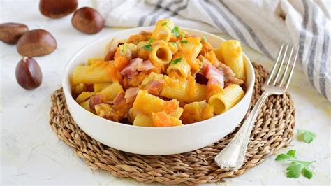 Foto di un tavolo imbandito con piatti tipici stagionali, tra cui zucca e castagne, in un ambiente rustico