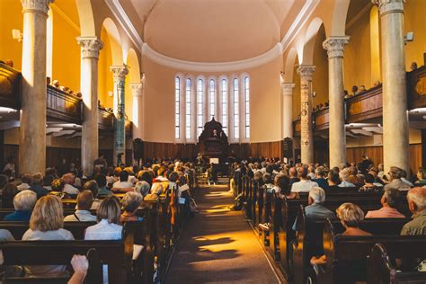 Interno di una chiesa moderna con fedeli che partecipano attivamente