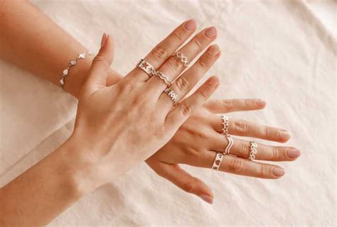 Donna che indossa un bracciale in argento con altri gioielli, mani eleganti