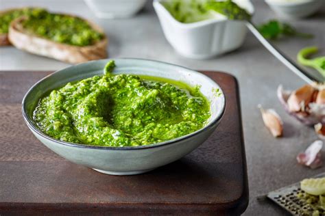 Foto di pesto di basilico senza aglio in una ciotola con pasta sullo sfondo