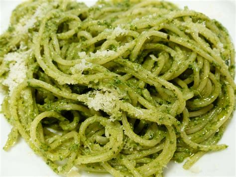 Vaso di pesto fatto in casa con spaghetti al pesto in un piatto