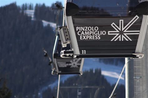 Immagine della telecabina Pinzolo - Campiglio Express con le montagne innevate sullo sfondo