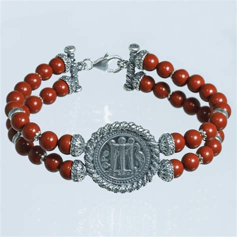 Illustrazione artistica di un bracciale in argento con rose in pasta di corallo e croce, simbolo di devozione a Santa Rita.