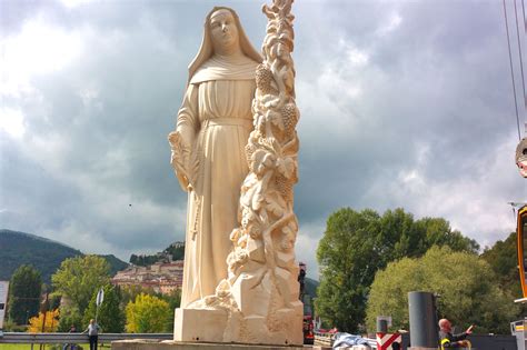 Statua di Santa Rita da Cascia con le sue caratteristiche iconografiche: la rosa, la spina e il crocifisso