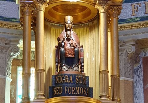 Dettaglio della statua della Madonna Nera di Tindari con la scritta latina