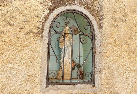 Edicola votiva addobbata con fiori e candele a Cefalù