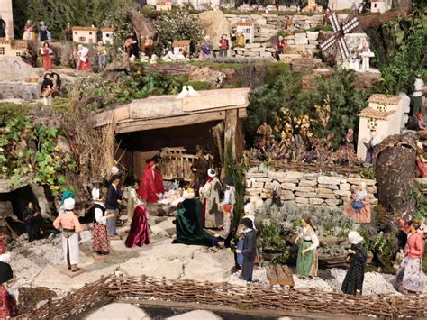 Famiglia che costruisce un presepe in casa, con materiali naturali e figure tradizionali
