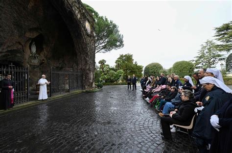 Foto di persone in preghiera alla Grotta di Lourdes o processione con fiaccole