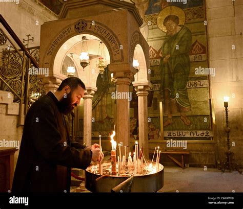 Foto di una chiesa vuota con un sacerdote che celebra e fedeli collegati tramite schermi
