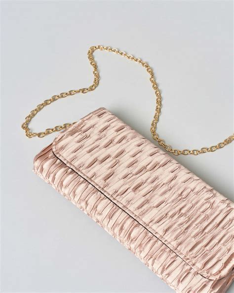 Pochette elegante e gioielli discreti per completare un outfit da battesimo
