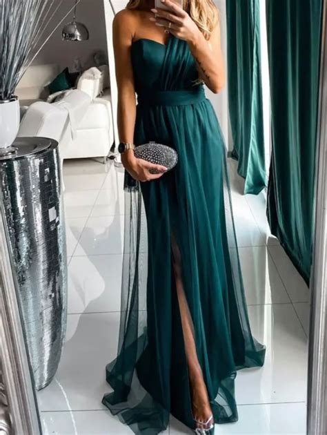 Donna elegante con vestito svasato di colore pastello per battesimo