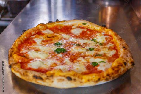 Primo piano di una pizza appena sfornata con ingredienti freschi e colorati