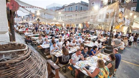 Foto panoramica di una sagra di paese in Veneto, con stand gastronomici e persone che partecipano agli eventi