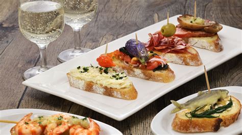 Foto di un assortimento di cicchetti veneziani con un bicchiere di vino
