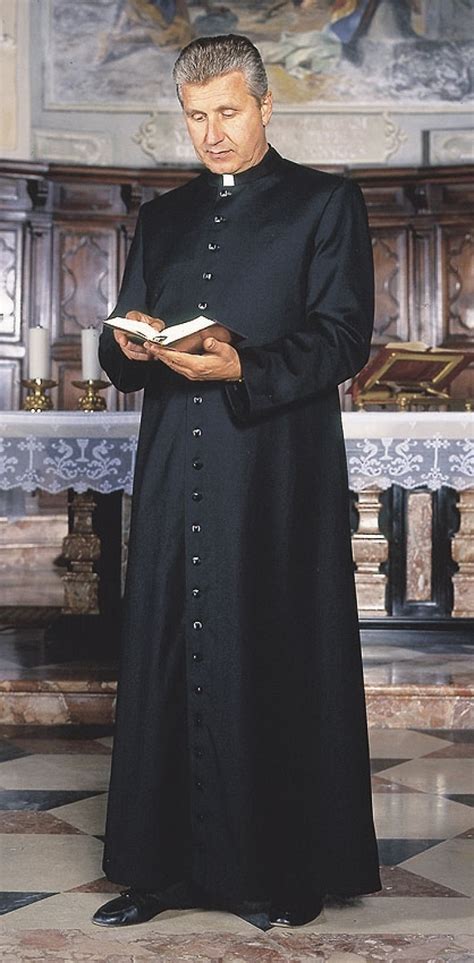 Don Davide Milani in veste talare, in posa sorridente