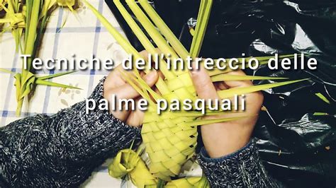 Dettaglio di mani che intrecciano foglie di palma per creare decorazioni artigianali.