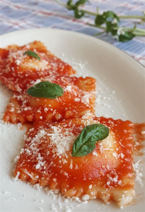 Foto di ravioli verdi al basilico con sugo di pomodoro e pinoli