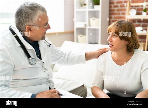 medico che assiste un paziente anziano su una poltrona