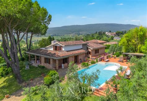 Veduta panoramica esterna della villa con giardino e piscina immersa nel paesaggio collinare delle Marche.