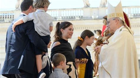Foto di famiglie e bambini durante una cerimonia di benedizione nella festa di Santa Rita
