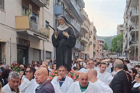 Foto di fedeli che accendono ceri e offrono rose a Santa Rita