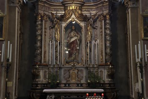 Un'immagine serena di un altare domestico con l'effigie del Sacro Cuore di Gesù in una stanza illuminata dalla luce tenue di una candela.
