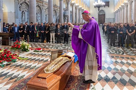 Sacerdote che saluta i fedeli dopo la Messa, con la comunità radunata attorno