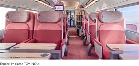 Interno di un treno TGV INOUI, mostrando i sedili comodi e lo spazio per i bagagli.