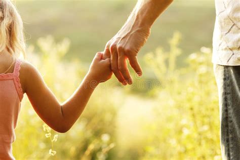 Un genitore che tiene una candela battesimale accesa, con il figlio accanto, durante una celebrazione