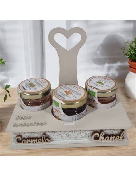 Tavola imbandita con diverse tipologie di bomboniere gastronomiche, tra cui vasetti di marmellata