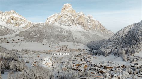 Foto panoramica dell'Hotel Betulla con le Dolomiti sullo sfondo, in estate o inverno