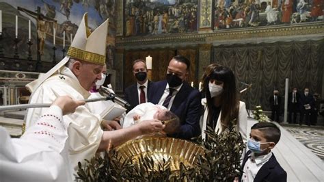 Sacerdote che battezza un bambino con i genitori e padrini