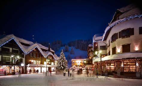 Panoramica invernale di Madonna di Campiglio con le Dolomiti di Brenta innevate e il paese illuminato