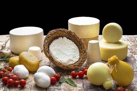 Tavola imbandita con selezione di formaggi stagionati e freschi, accompagnati da pane e vino