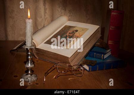 Foto di un angolo di preghiera semplice con una Bibbia aperta, una candela accesa e una statua della Madonna