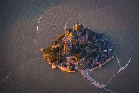 Veduta panoramica dell'abbazia di Mont Saint-Michel che emerge dalla baia durante l'alta marea